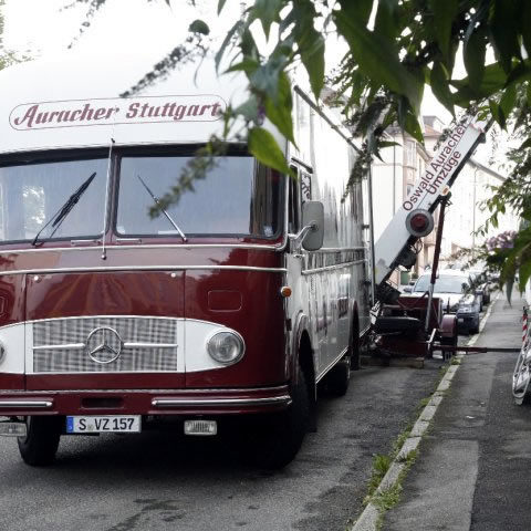 Historischer Möbelwagen der Firma Auracher mit Außenaufzug im Einsatz in einer Wohnstraße in Stuttgart